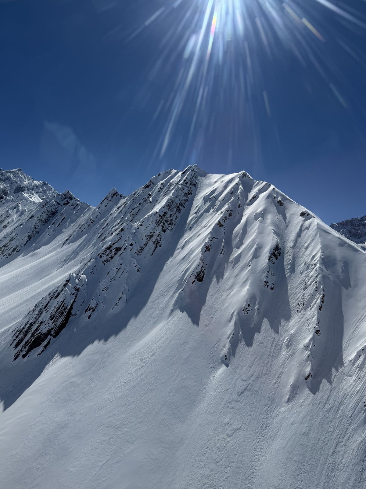 Sunlit Andes peak with steep snow-filled couloirs